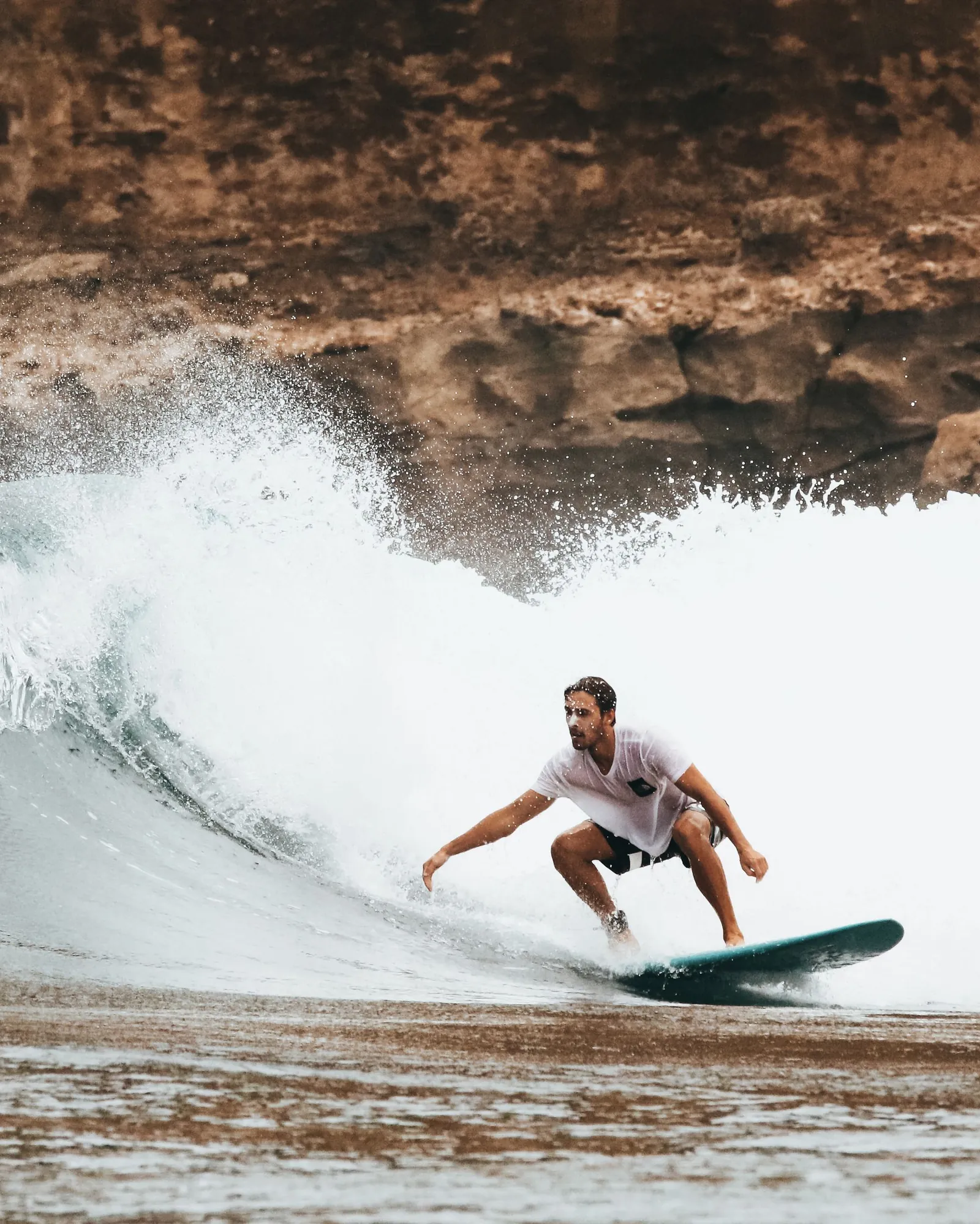 Un surfeur suit la paroi d’une vague bleue